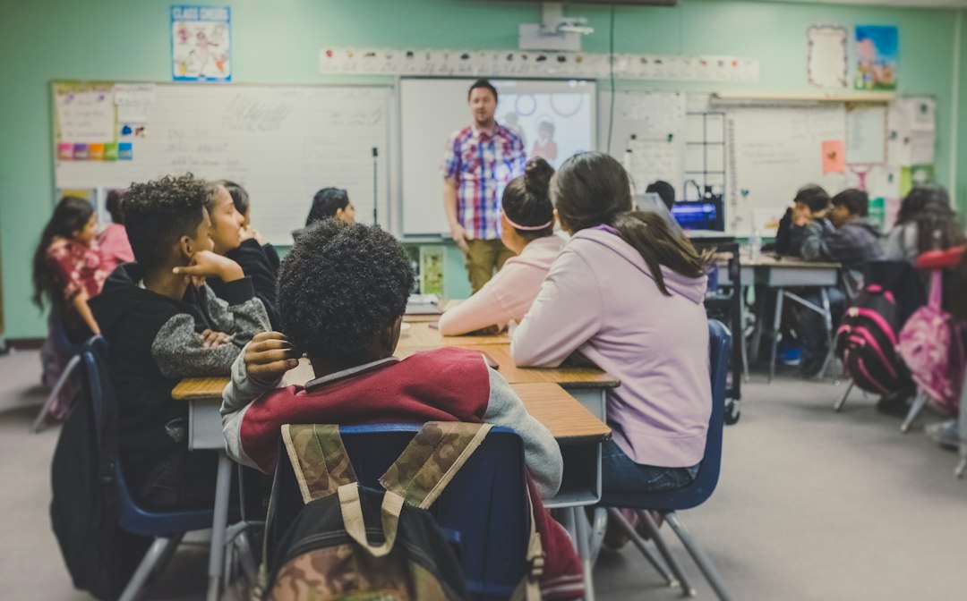 Estudiantes en un aula con una docente; imagen ilustrativa sobre educación